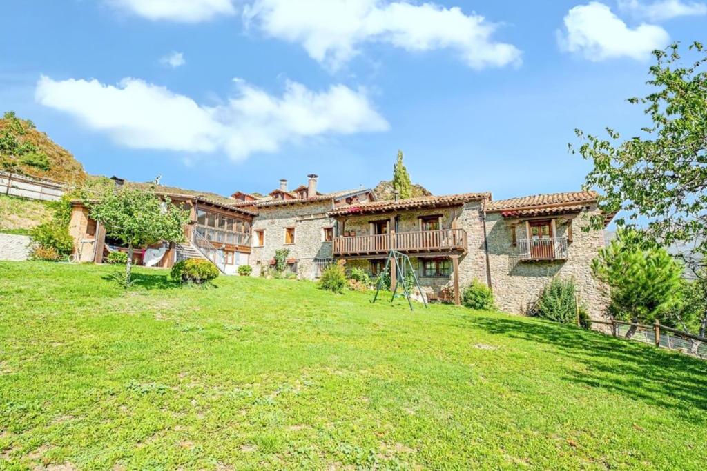 a large stone house with a green yard at Comfortable apartment in Ardanué - 55 m² - Parking available in Ardanué