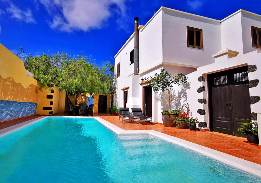 a villa with a swimming pool in front of a house at Apartamento Abajo, Casa la Costa in La Costa