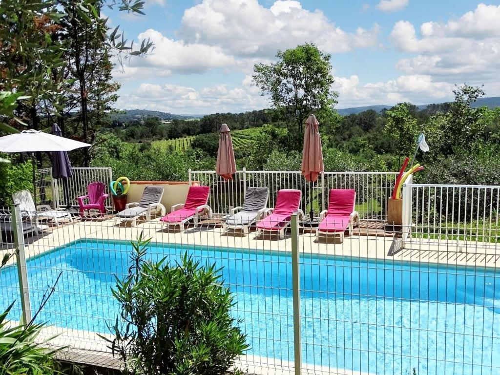 - une piscine avec des chaises longues et des parasols dans l'établissement Maison charmante à Cardet avec piscine partagée, à Cardet