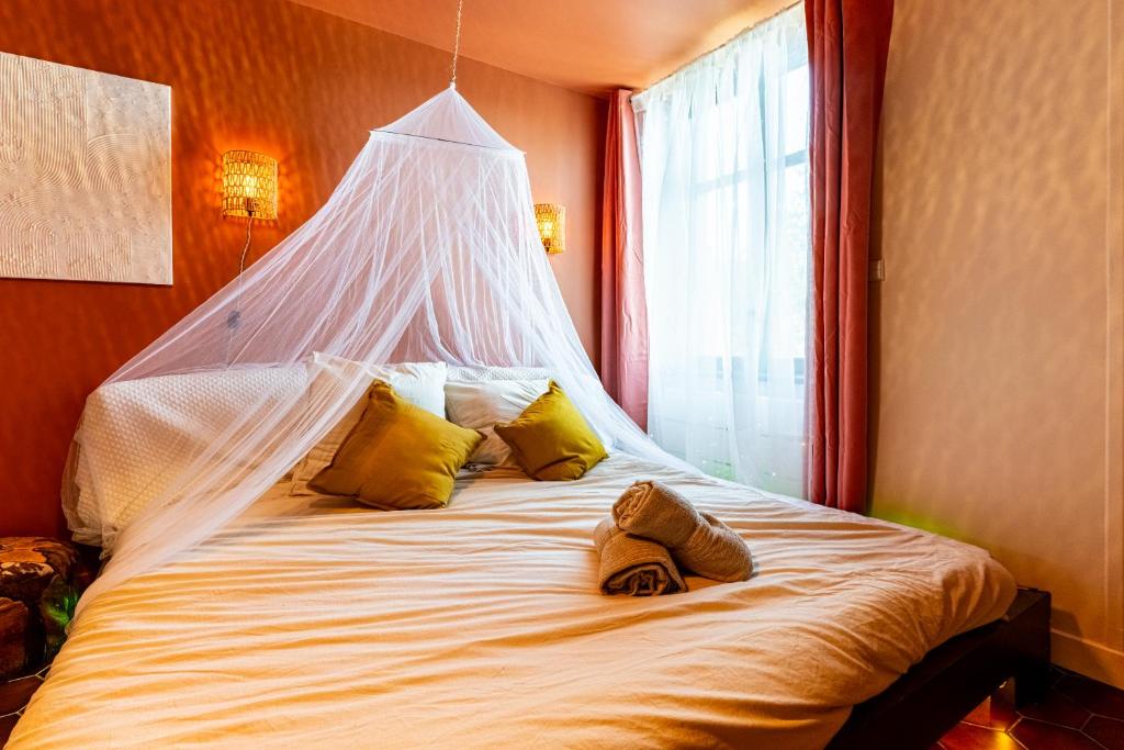 a large white bed with a net on top of it at Marrakech - Rêve d'Orient in Dijon