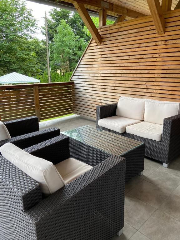 a patio with two wicker chairs and a table at Villa Arkodes in Gdańsk