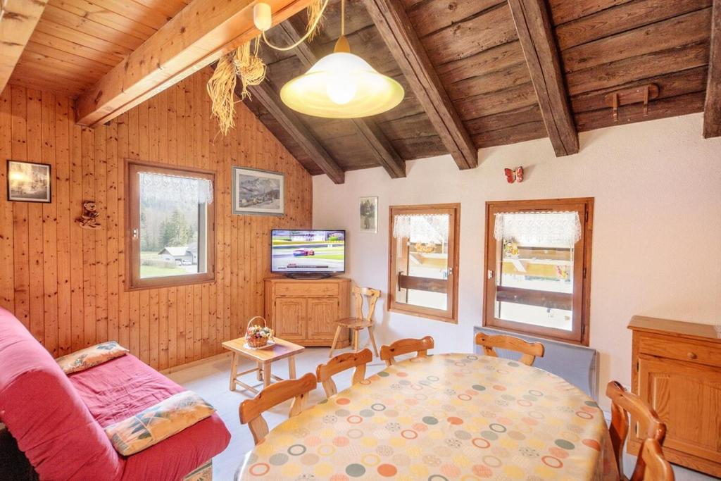 un salon avec une table et un canapé dans l'établissement Pervenche, à Morillon