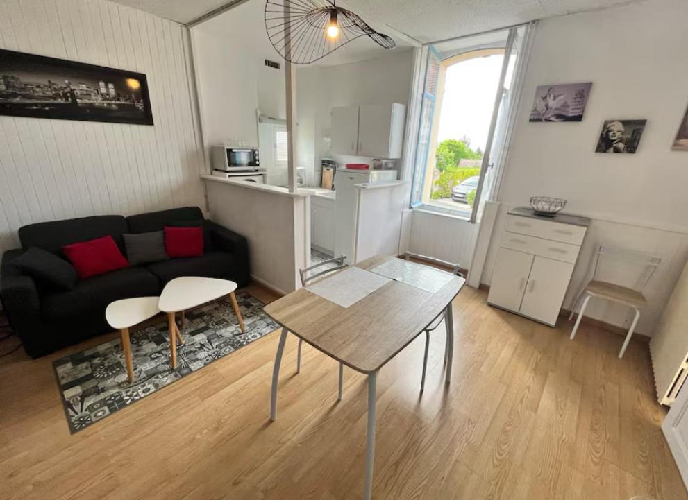 un salon avec un canapé et une table dans l'établissement Les terrasses de Massenet 1, à Néris-les-Bains