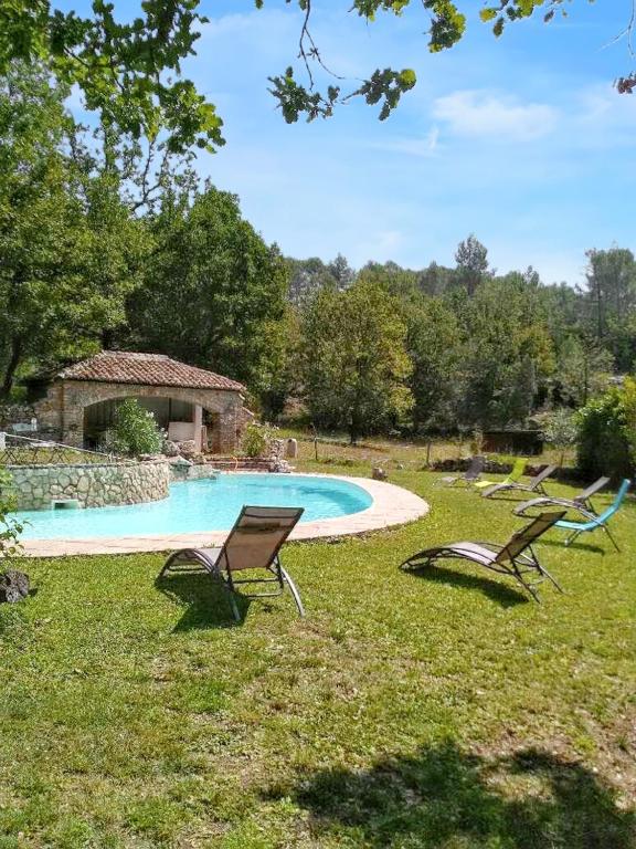 dwa krzesła siedzące w trawie przy basenie w obiekcie Villa charmante avec piscine privée à Montferrat - 125 m² w mieście Montferrat