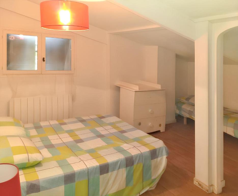 sypialnia z łóżkiem z kocem w kratę w obiekcie Villa charmante avec piscine privée à Montferrat - 125 m² w mieście Montferrat