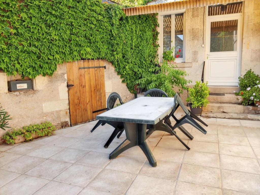 a picnic table on a patio in front of a building at Chaleureuse Maison de Campagne avec Terrasse et Cheminée in Lignières-de-Touraine