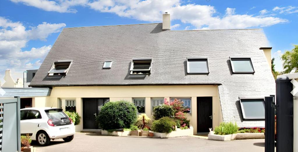 Un coche blanco aparcado delante de una casa en Maison moderne à Saint-Pol-de-Léon avec jardin privé, en Saint-Pol-de-Léon