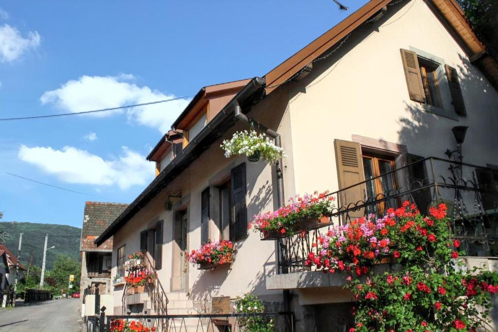 stary budynek z kwiatami na balkonach w obiekcie Maison de charme à Wuenheim avec jardin et terrasse w mieście Wuenheim