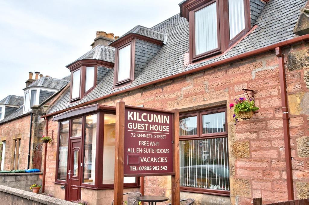 
a brick building with a sign on the side of it at Kilcumin Guest House in Inverness
