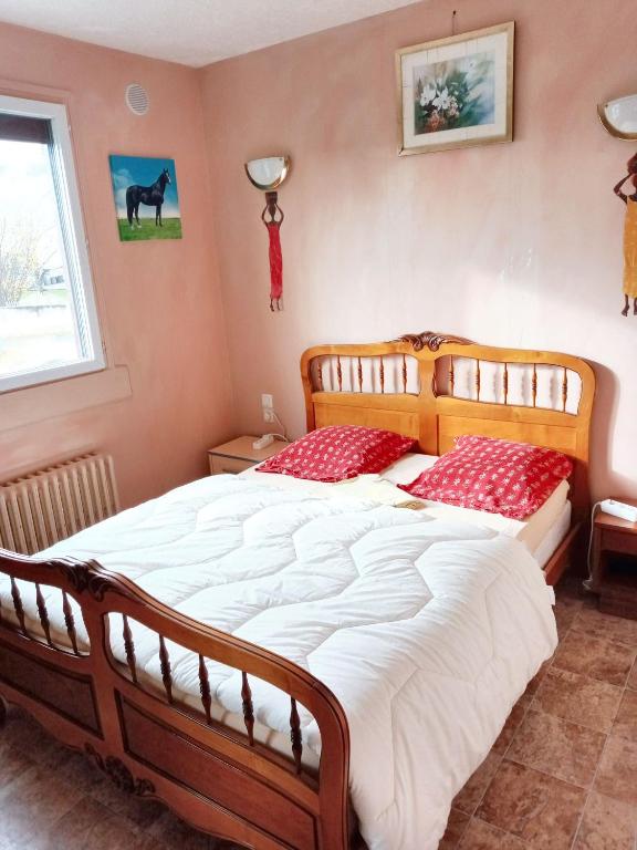 une chambre avec un grand lit et une fenêtre dans l'établissement Maison accueillante à Montluçon avec jardin privatif, à Montluçon