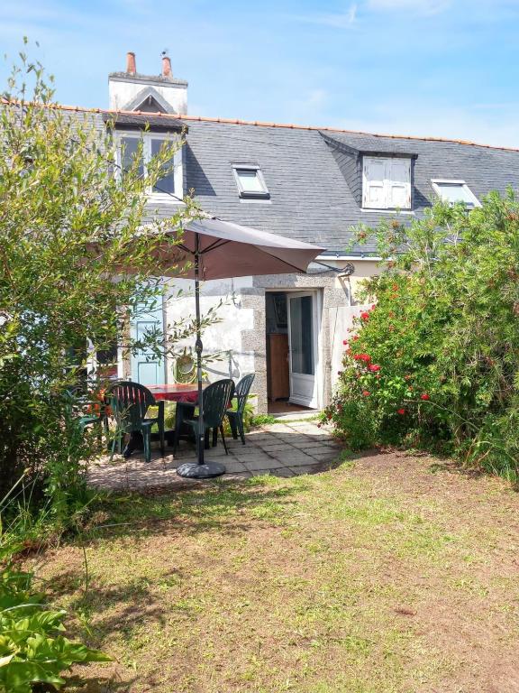 a patio with a table and chairs and an umbrella at Maison accueillante à Camaret-sur-Mer - Jardin spacieux 38 m² in Camaret-sur-Mer