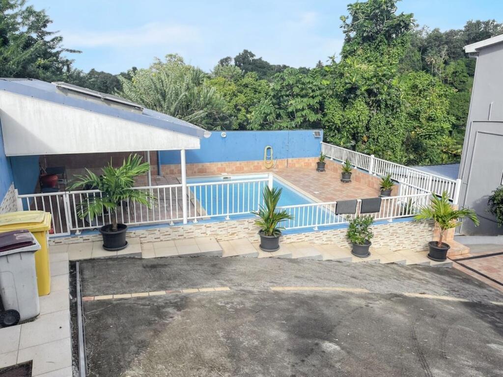 a house with a blue swimming pool with plants at Villa charmante près de Saint-Esprit avec piscine privée in Quartier Monplaisir