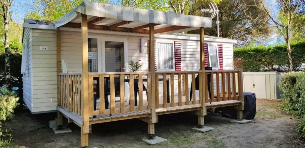 une petite maison avec un toit sur une terrasse dans l'établissement Bungalow confortable à Saint-Jean-de-Monts avec piscine partagée, à Saint-Jean-de-Monts