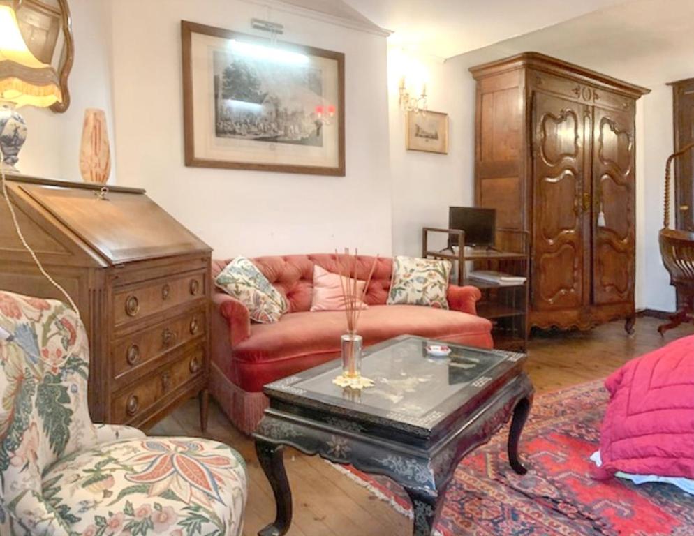 un salon avec un canapé rouge et une table dans l'établissement Appartement charmant à Sainte-Croix-du-Mont avec jardin, à Sainte-Croix-du-Mont