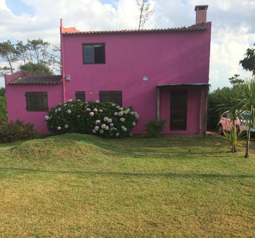 a pink house with flowers in front of it at La Rosada in La Paloma