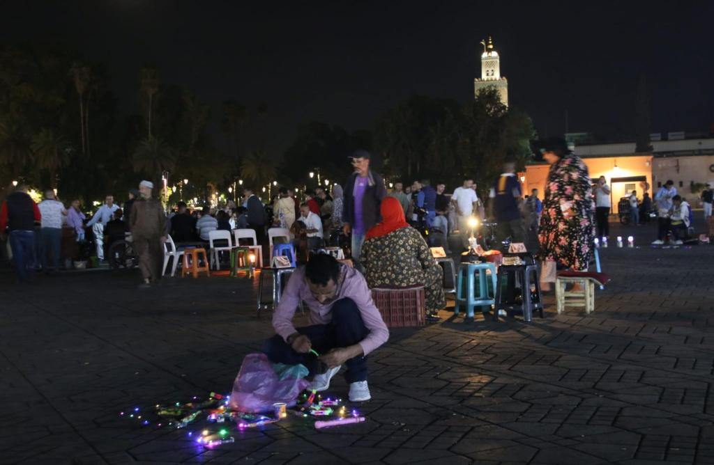 a man sitting on the ground with christmas lights at Marokkoreizen in Fès
