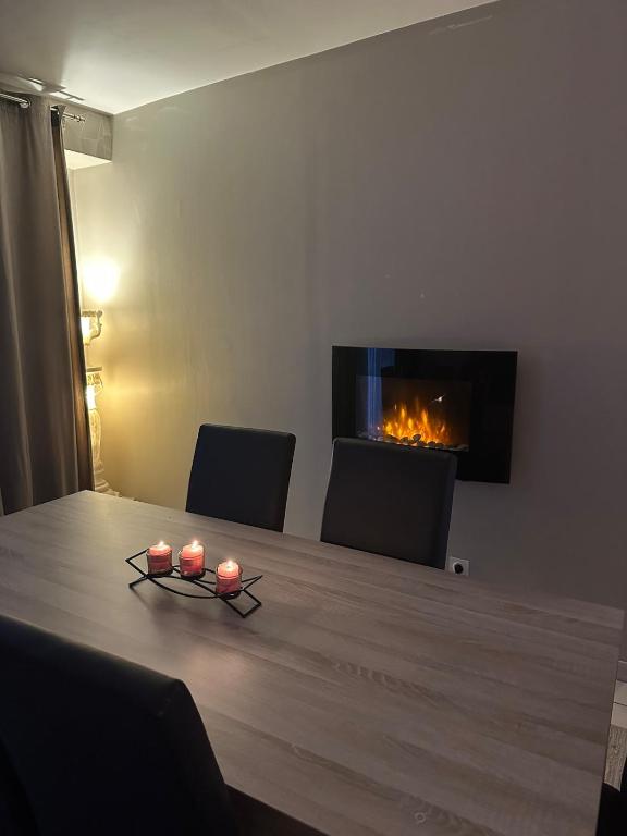 une pièce avec une table avec des bougies et une cheminée dans l'établissement Maison cosy centre-ville, à Luxeuil-les-Bains