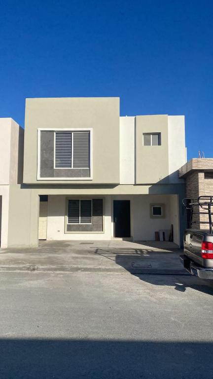 Ramos Arizpeexecutive home, vacation work的前面有一辆汽车停放的白色房子