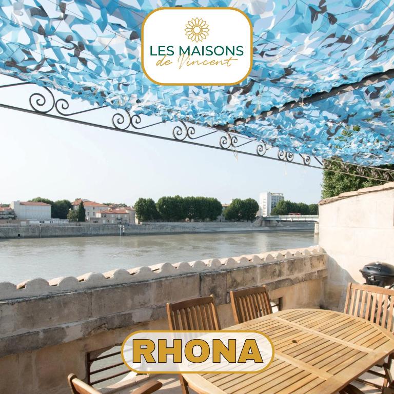 d'une table et de chaises avec vue sur la rivière. dans l'établissement Rhona, Terrasse vue sur le Rhône, à Arles