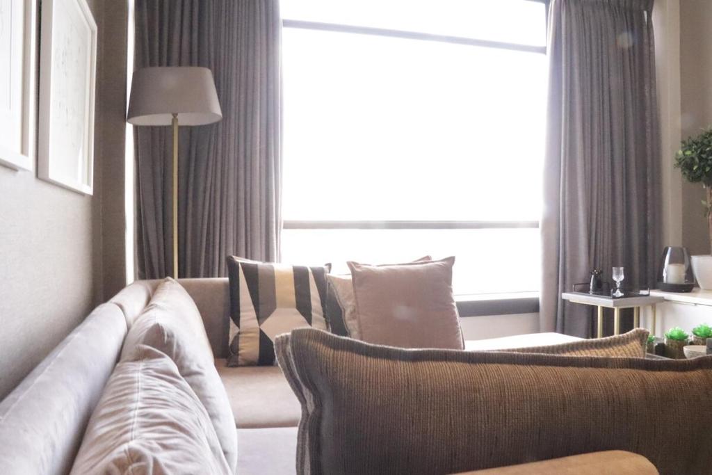 a living room with a couch and a window at Condo in Sandton Masingita Tower in Johannesburg