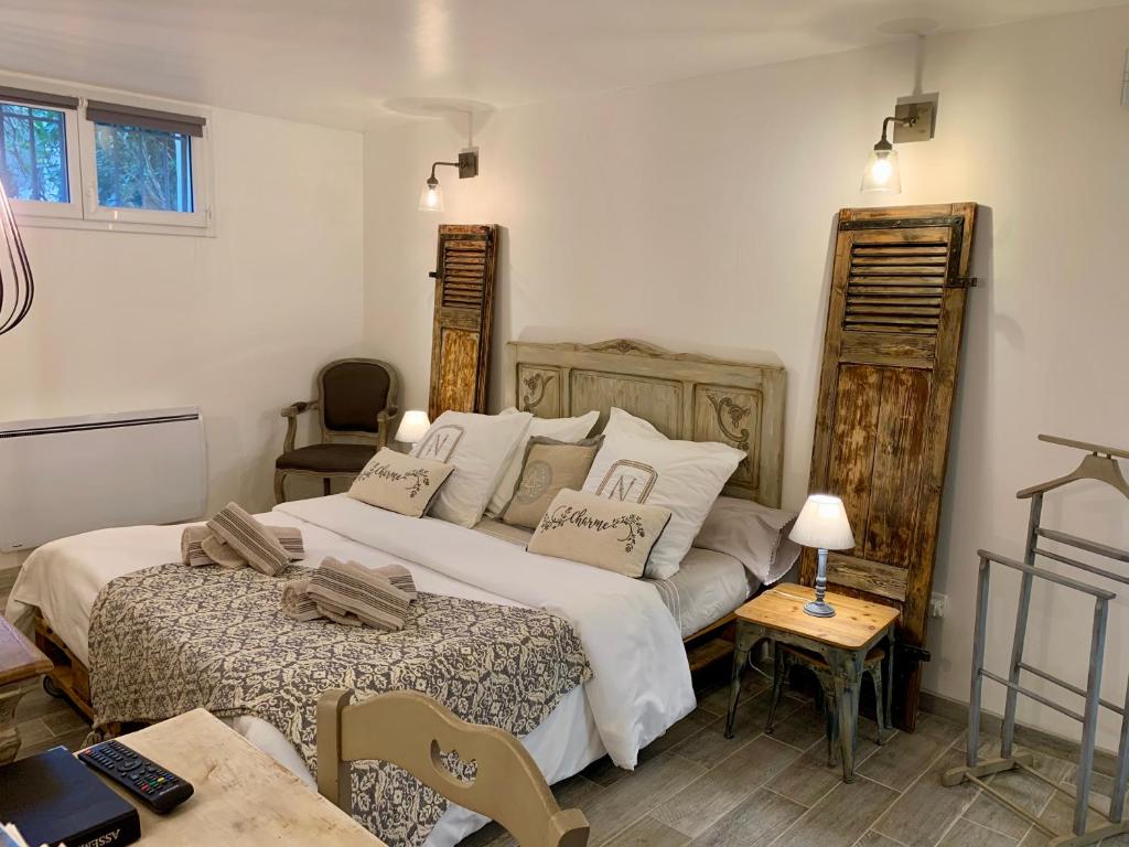 ein Schlafzimmer mit einem großen Bett und einem Tisch in der Unterkunft Les pondres en vaunage in Caveirac