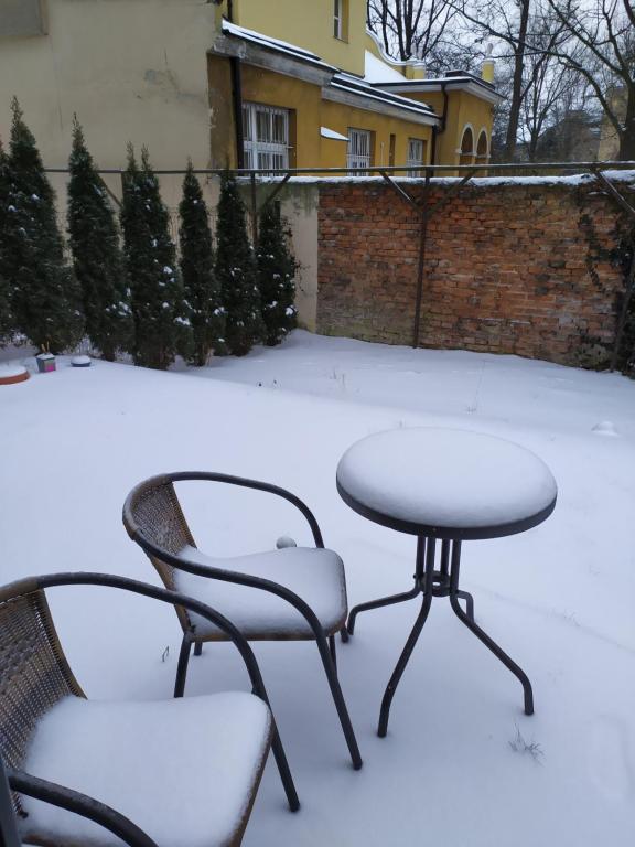 a table and two chairs in the snow at Studio with private Garden in Kraków