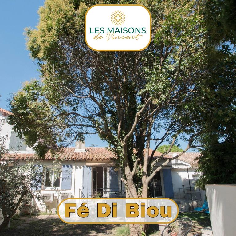 un panneau devant une maison avec un arbre dans l'établissement Fé Di Biou - Jardin Parking Clim, à Arles