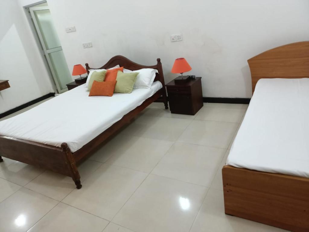 sypialnia z 2 łóżkami i 2 lampami w obiekcie Mirissa Ocean Breeze Hotel Triple room w mieście Mirissa