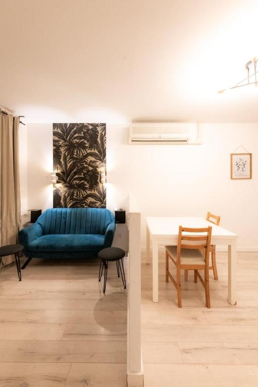 un salon avec un canapé bleu et une table dans l'établissement Appartement Central Lyon 3ème, à Lyon