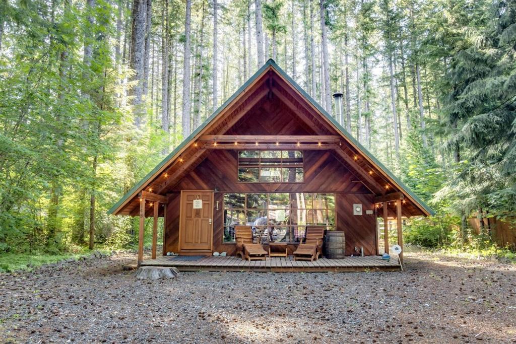 una cabaña en el bosque con mesa y sillas en Elk Drop Inn, en Packwood
