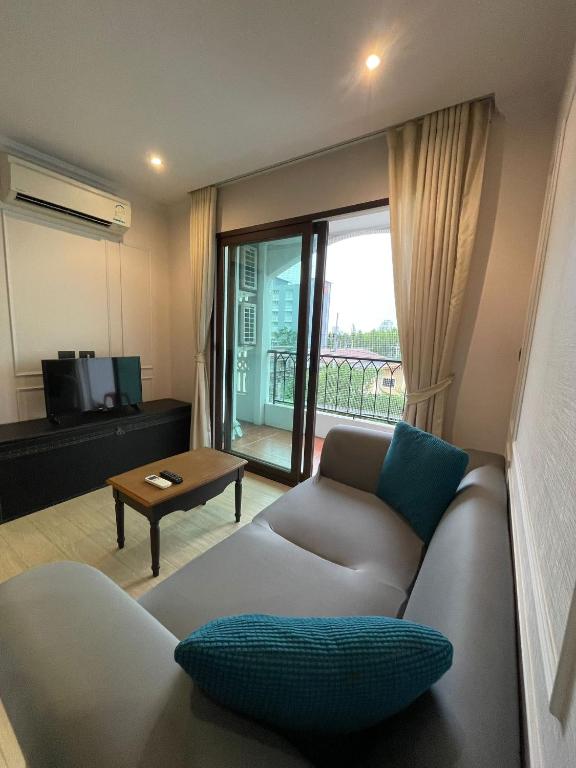 a living room with a couch and a table at Eleanor Homes in Jomtien Beach