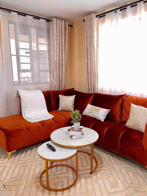 a living room with a red couch and a table at Bella Homes 2br Thika Town in Thika