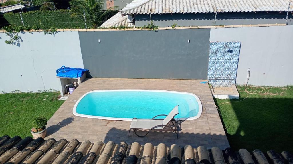 a swimming pool in a yard with a chair next to it at Vianna's House in Buzios