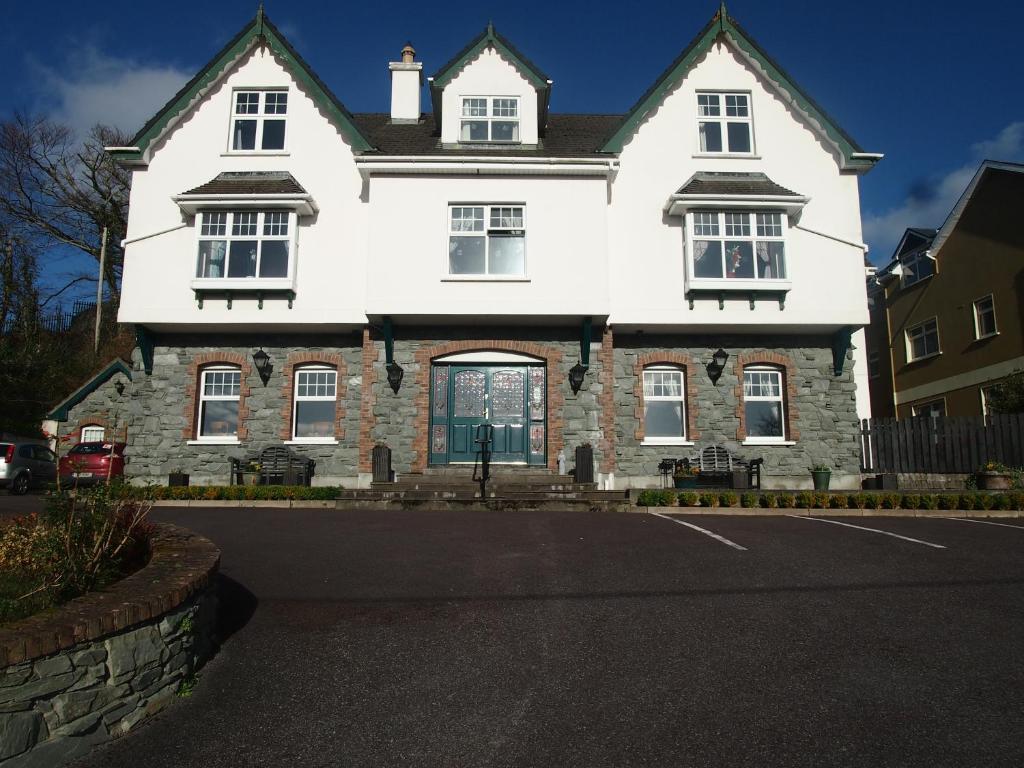 una gran casa blanca con entrada en Woodlawn House, en Killarney
