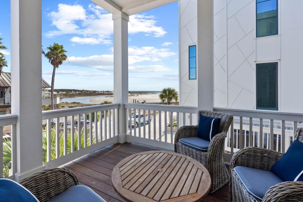 a porch with chairs and a table and a view of the beach at Grayt Digs by AvantStay Next to Beach Oceanview in Santa Rosa Beach
