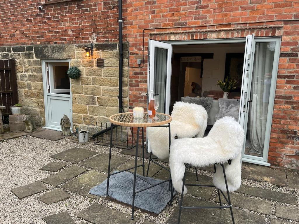 a patio with a table and chairs in front of a brick building at Bridle Cottage in Pentrich