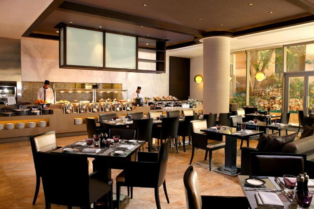a dining room with tables and chairs and a restaurant at Gefinor Rotana &ndash; Beirut in Beirut