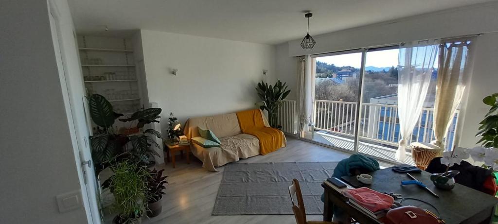 un salon avec un canapé et une grande fenêtre dans l'établissement Appartement, à Gap