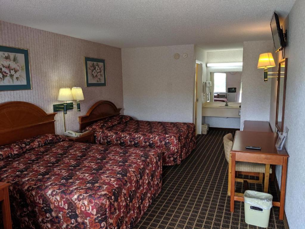 a hotel room with two beds and a desk at Economy Inn Express in Rock Hill