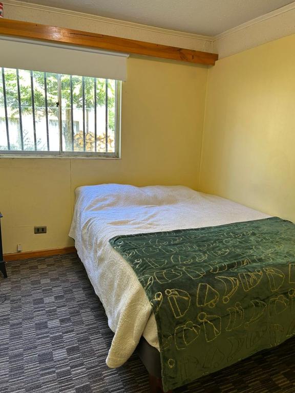 a bedroom with a bed and a window at Condominio Entre Ríos in Valdivia