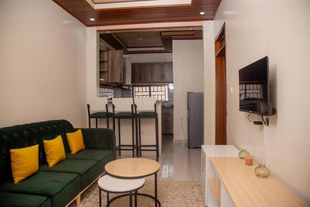 un soggiorno con un divano verde e una cucina di La Perle de Ville a Kigali