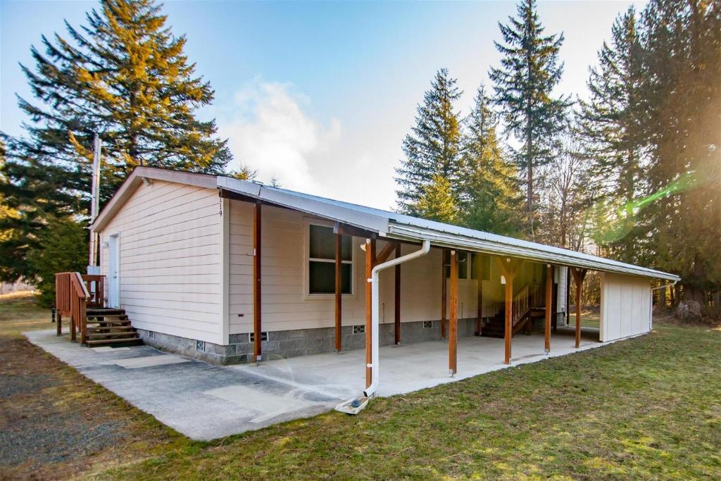 a small white house with a porch at Little Woods Outpost in Packwood