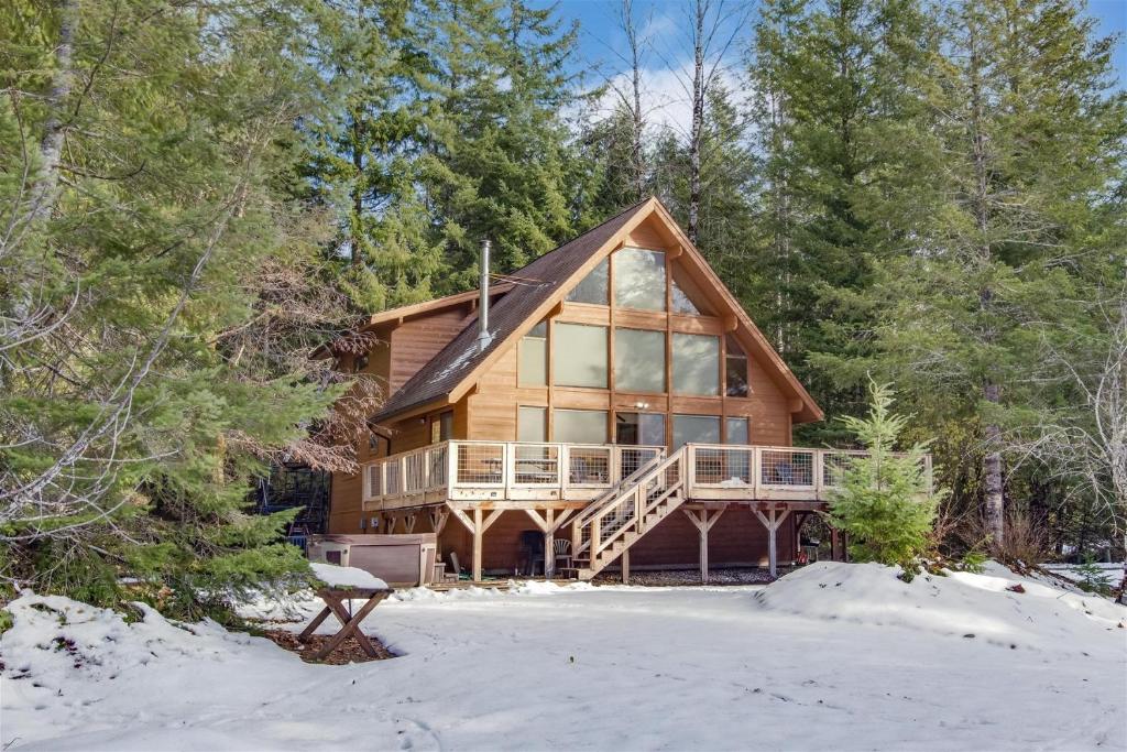 a large wooden house with a deck in the snow at Trails End | Hot Tub, Starlink, Woodstove in Packwood