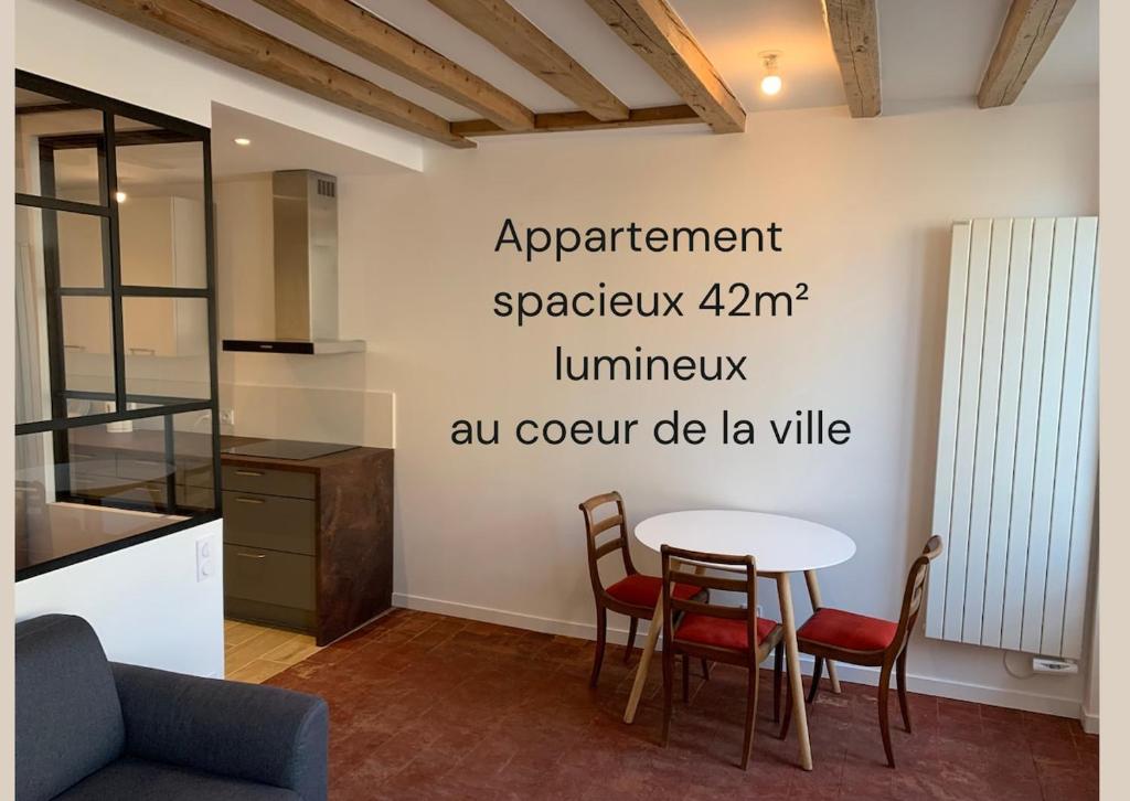 a kitchen with a table and chairs in a room at Le Nid Urbain in Villefranche-sur-Saône