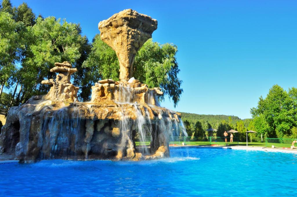 una fontana al centro della piscina di Camping Caravaning Cuenca a Cuenca
