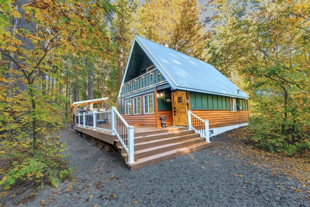 a cabin in the woods with a large porch and stairs at Wonderland Chateau in Packwood