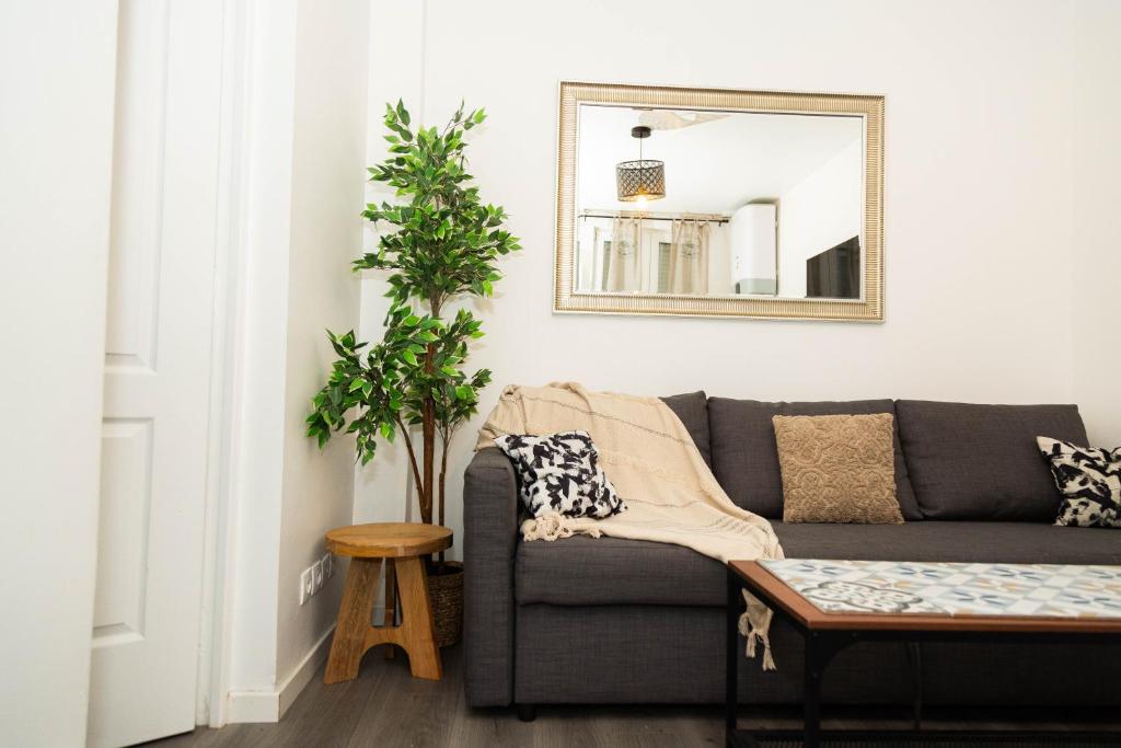 un salon avec un canapé et un miroir dans l'établissement Charment studio stade de France 18 pour 4 personnes, à Saint-Denis