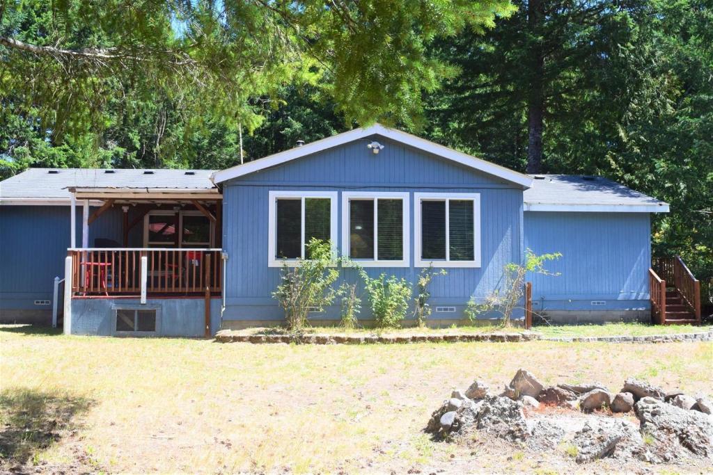 a blue tiny house in a yard at Rustic Rapids · Wood Stove, Creek, Sauna in Packwood