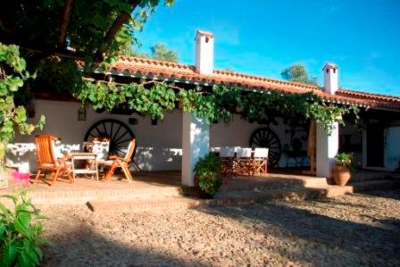 un patio de una casa con mesa y sillas en La Caldera Vieja, en Zalamea la Real