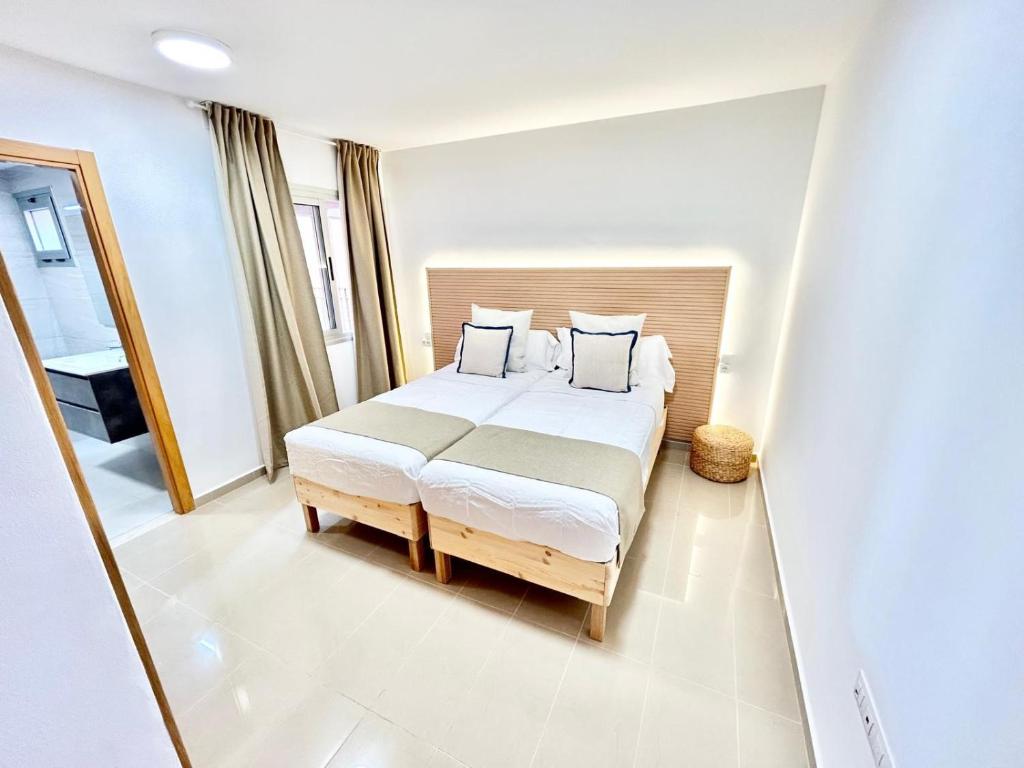 a bedroom with a bed with white sheets and pillows at VV Canary Islands 1 in San Miguel de Abona